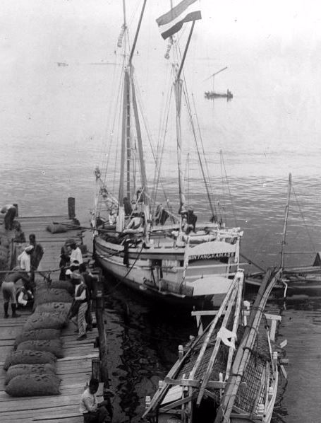 Sebuah perahu dengan layar sekunar dan sebuah padewakang di Pelabuhan Makassar, 1920-an; Koleksi Wereldculturen TM-10010383